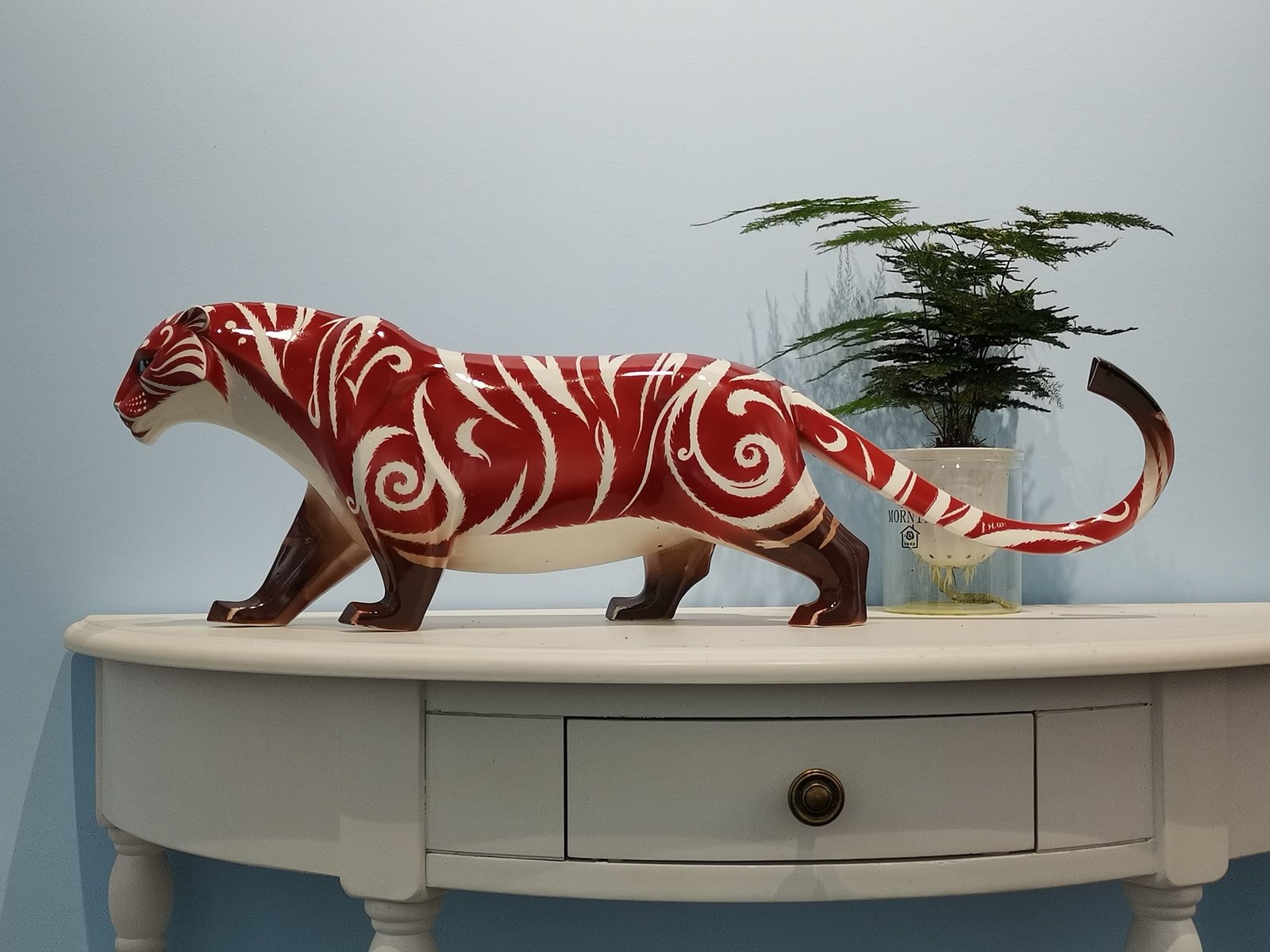 Red ceramic tiger sculpture displayed in a contemporary interior